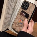 Coach 風モノグラムキャラクターカードポケット付き iPhone17 15 13 スマホケース 個性的なデザインと高級感を融合したファッションアイテム